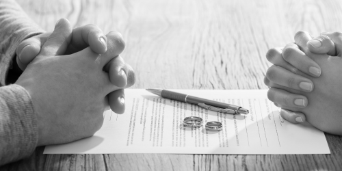 Page between two people, a man and a woman, their hands clasped together as they sit across from one another
