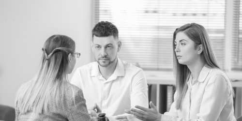 A couple sit across from another woman in a professional setting