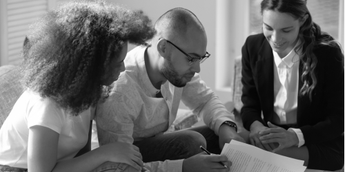 couple signing a prenuptial with their attorney, a woman in professional dress