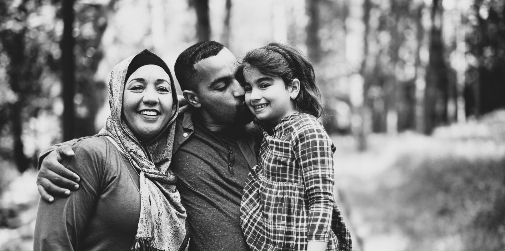 Happy Muslim parents with daughter enjoying a day in nature.