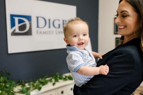 A Digby Family Law attorney smiles at a baby in her arms.